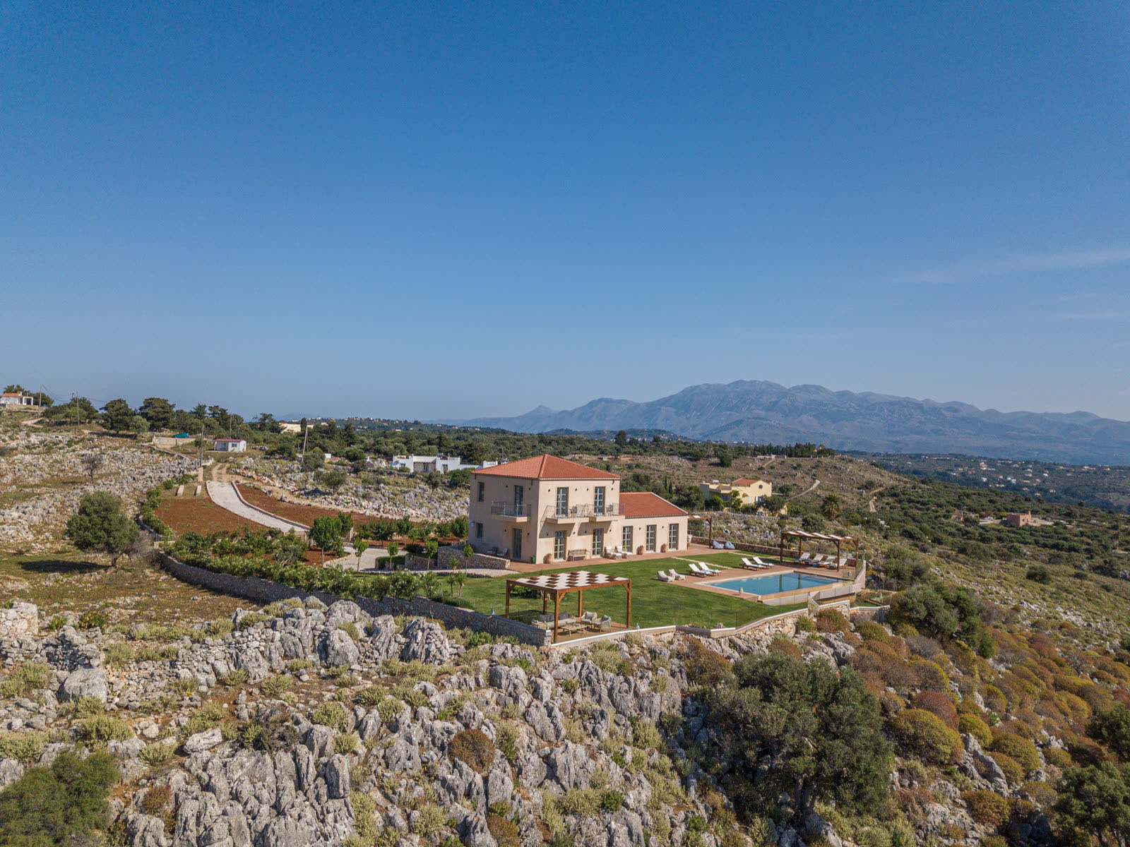 Aerial view of Aquila Villa on its hilltop plot with lawn, pool and countryside