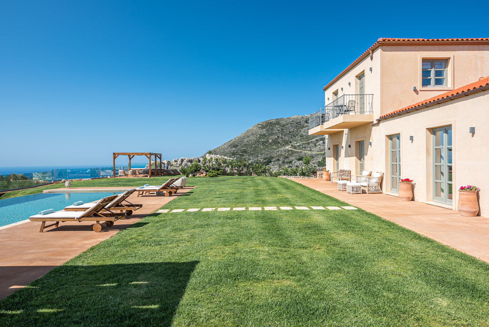 Manicured lawn, stepping stones, pool and villa