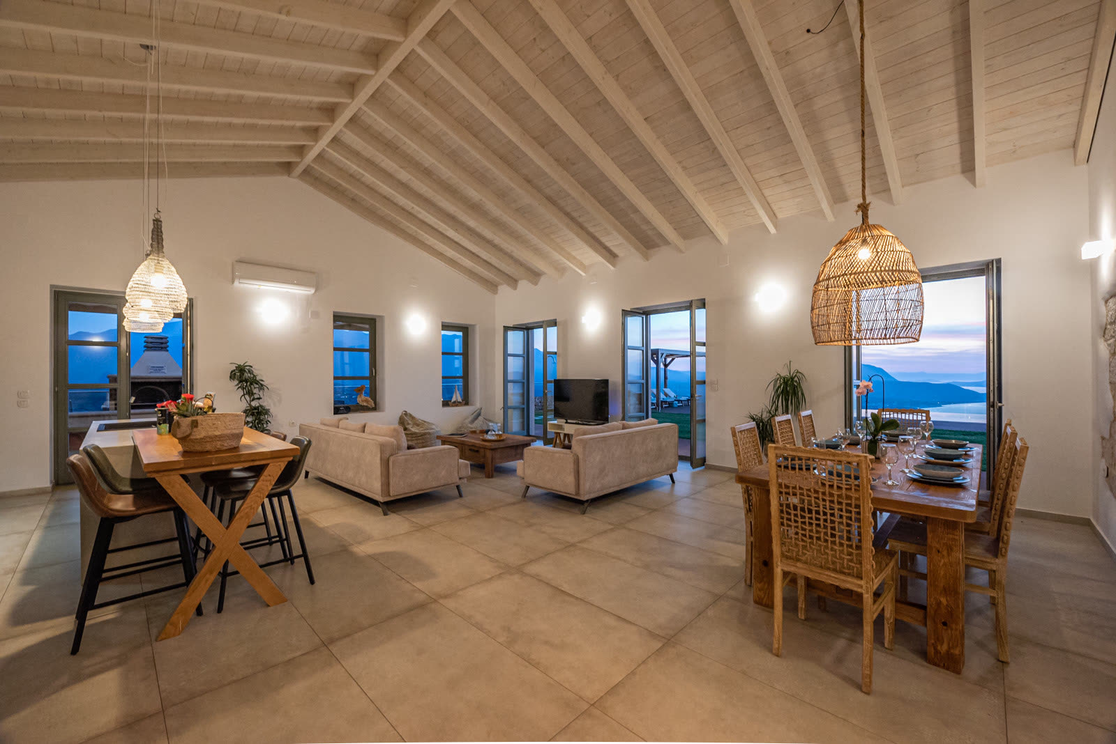 Open-concept living and dining under a vaulted wood ceiling